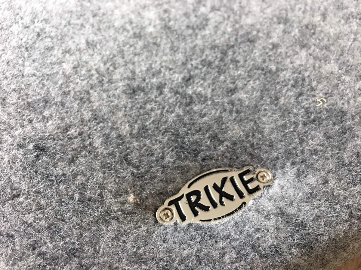 Nahaufnahme des grauen Filzbezugs von Hugo mit dem Trixie-Logo