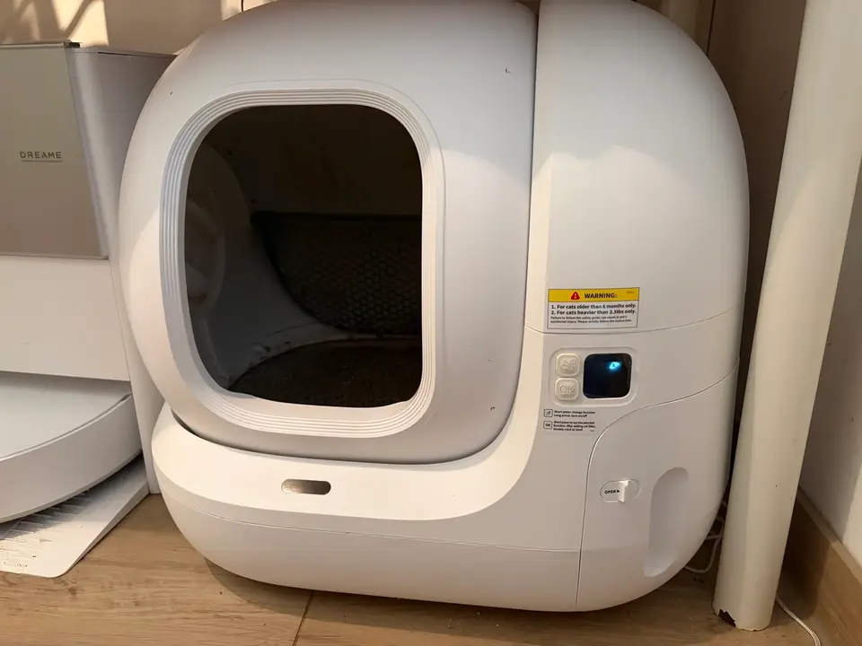 Das PETKIT Pura Max 2 steht bei uns an der Wand: weißes, rundes Katzenklo mit großer Einstiegsöffnung und Display